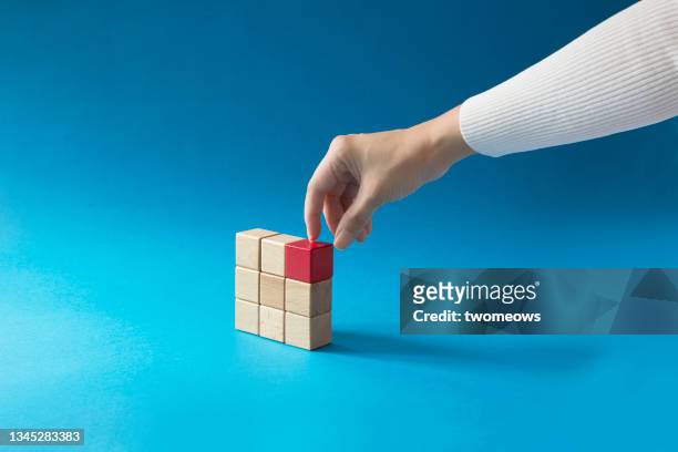 singled out concepts still life with hand stacking cubes. - nehmen stock-fotos und bilder