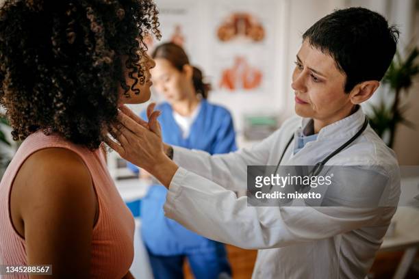 doctora que realiza un examen médico - thyroid gland fotografías e imágenes de stock