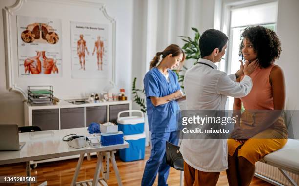 femme médecin effectuant un examen médical - système endocrinien photos et images de collection