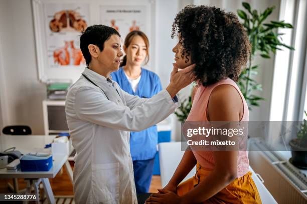 female doctor doing a medical examination - schildklier stockfoto's en -beelden