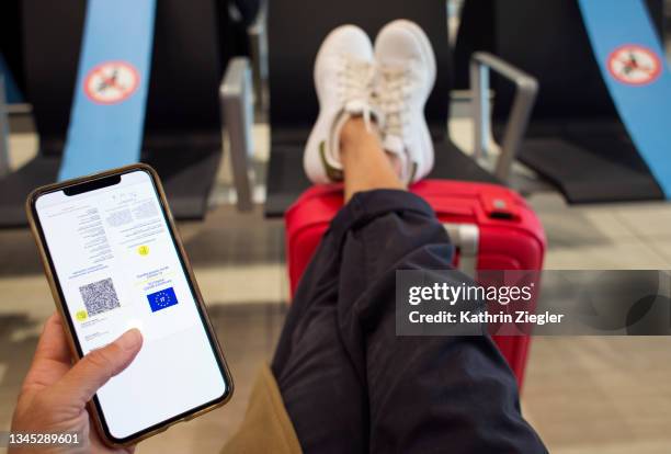 the new normal: traveling with green pass - phone screen at airport stockfoto's en -beelden