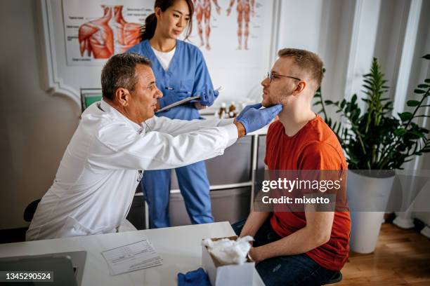 doctor doing a medical examination - schildklier stockfoto's en -beelden