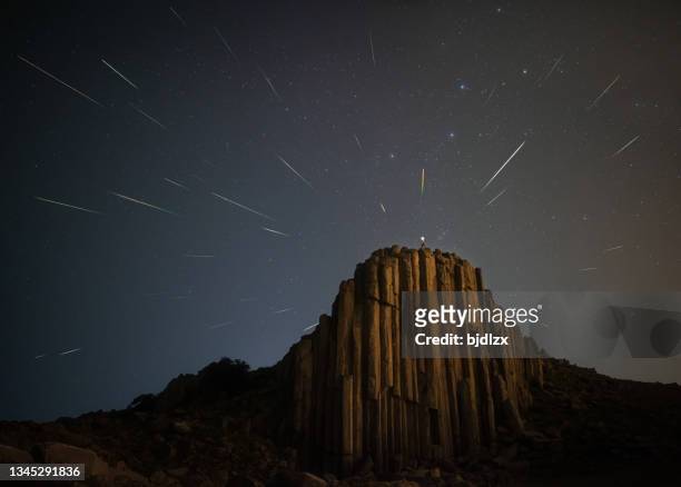 perseid meteor shower over ancient basalt rock column - basalt stock pictures, royalty-free photos & images