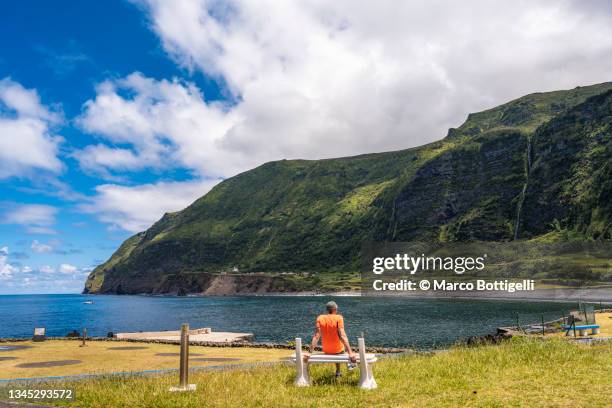 man sitting on a bench looking at view, azores islands, portugal - flores stock-fotos und bilder