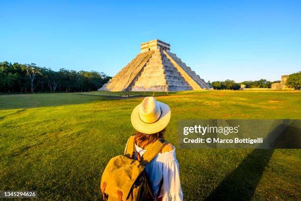 woman admiring the temple of kukulcan (el castillo) in chichen itza, yucatan, mexico - mayan people stockfoto's en -beelden