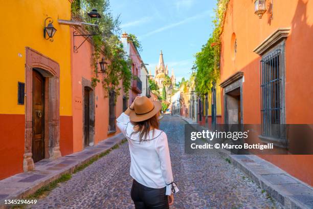 woman admiring the parish church in san miguel de allende, mexico - ciudadanos mexicanos fotografías e imágenes de stock