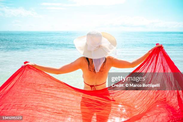 beautiful woman holding a red sarong on idyllic tropical beach, mexico - playa del carmen photos et images de collection