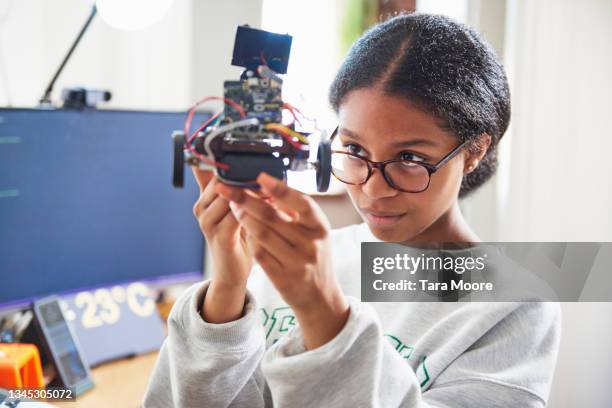 teenage girl building robot - science or technology stockfoto's en -beelden