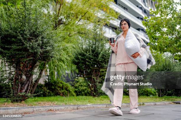 businesswoman holding pillow and walking in pyjamas and slippers - pijama imagens e fotografias de stock
