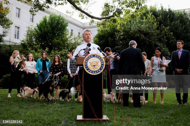 Senate staff members and their dogs look on as Sen. Rand Paul speaks at a press conference on his FDA Modernization Act on Capitol Hill on October...