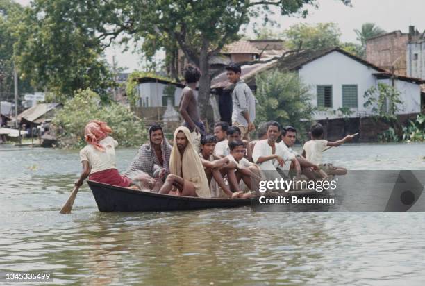 Bengalese refugees paddle through flooded area of Calcutta, India, 23rd September 1971.