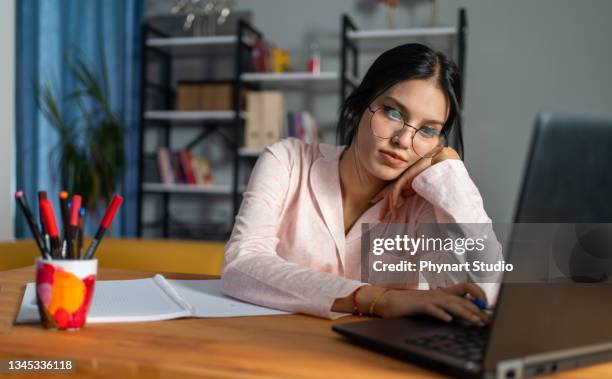 studiare fino al mattino - woman lying on stomach with feet up foto e immagini stock