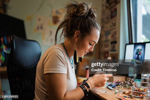 female small business owner, making an hadmade custom jewlery in her home workshop - costume jewellery stock pictures, royalty-free photos & images