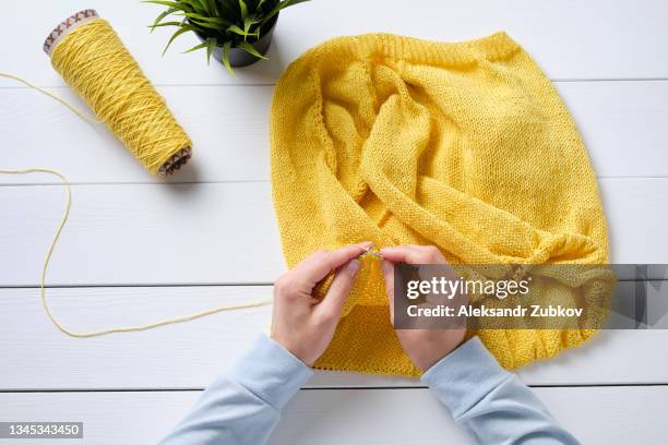 summer knitted sweater or cardigan made of cotton or wool. nearby lies a skein of yarn and knitting needles against the background of a white wooden table. freelance is a creative concept of work and life, a hobby. creating clothes with your own hands. - crochet stock pictures, royalty-free photos & images