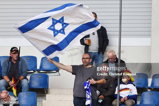 Fan of Israel waves a flag during the 2022 UEFA European Under-21 Championship Qualifier match between Germany and Israel at Benteler Arena on...