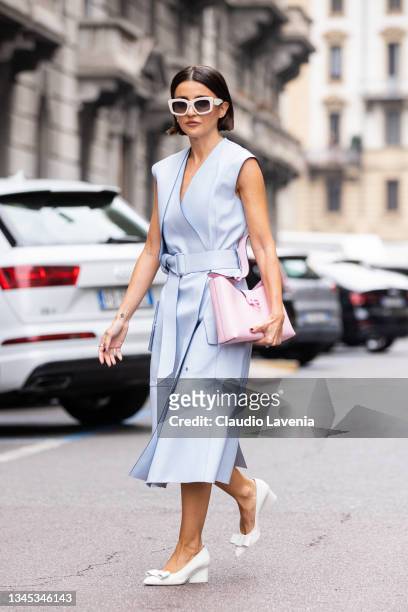 Alexandra Pereira, wearing light blue midi dress, pink Ferragamo bag, white Ferragamo heels, poses ahead of the Ferragamo fashion show during the...