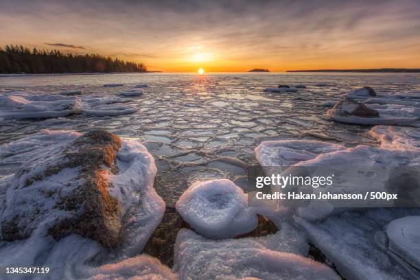 scenic view of frozen lake against sky during sunset,sweden - soluppgång stockfoto's en -beelden