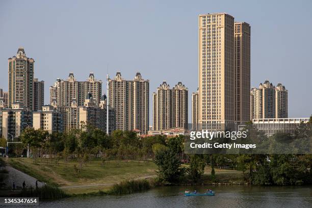 People canoe in a lake past the Evergrande city during the last day of the National Day and Golden Week holidays on October 7, 2021 in Wuhan, Hubei...