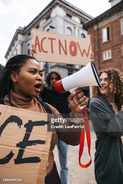 anti-racism protest in the city street. a group of students marching together - activist stock pictures, royalty-free photos & images