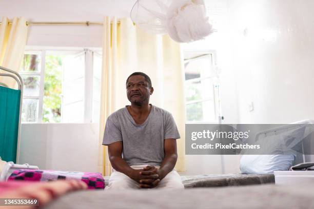 man sits alone in a hospital room waiting for help - hospital waiting room stockfoto's en -beelden