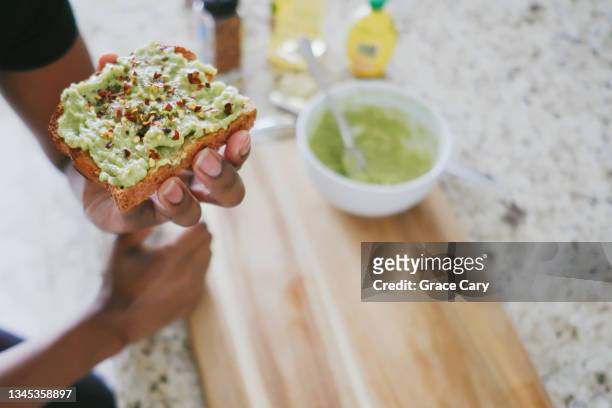 woman eats avocado toast - woman eating toast photos et images de collection