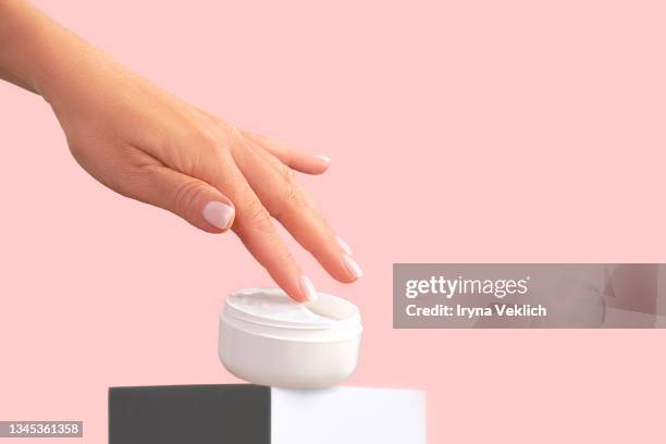 beautiful female hand with jar of organic  moisturizing facial cream  or hand cream. routine step for healthy skin care. - cosmetic jar stockfoto's en -beelden