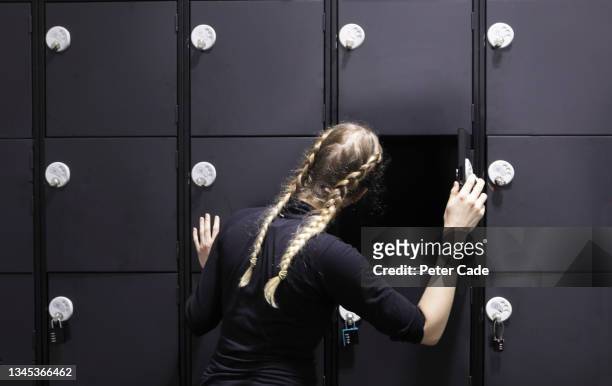 woman looking into empty locker - vestiaires casier sport photos et images de collection