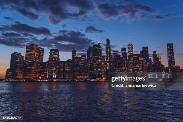 financial district cityscape at sunset with 120 wall street, continental center and freedom tower at night, manhattan, new york, usa - wall street photos et images de collection