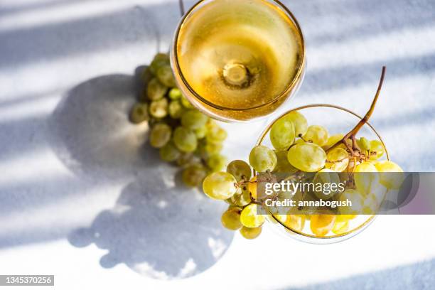 champagne coupe filled with a bunch of fresh grapes and glass of white wine - white wine overhead stock pictures, royalty-free photos & images