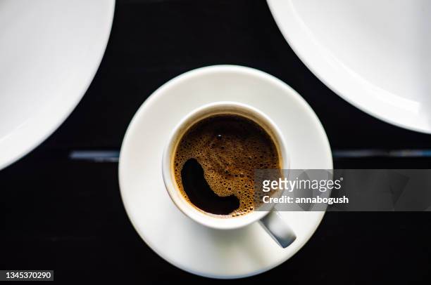 overhead view of a cup of turkish coffee on a table next to two plates - turkish coffee fotografías e imágenes de stock