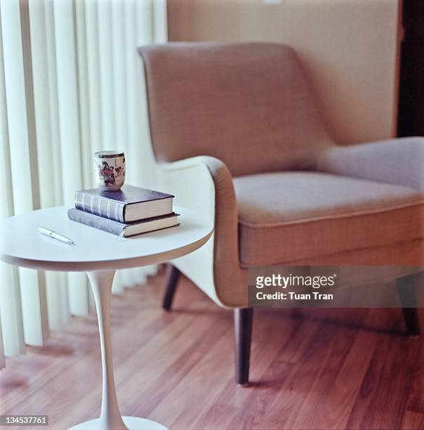 tea cup, pen and books on table - side table stock pictures, royalty-free photos & images