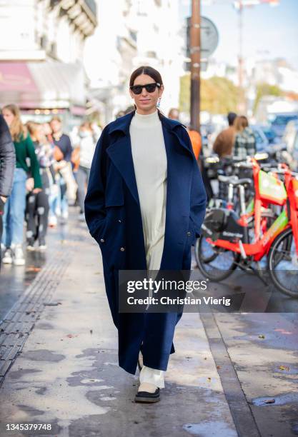 Deborah Reyner Sebag seen wearing navy coat, creme white dress outside Lacoste during Paris Fashion Week - Womenswear Spring Summer 2022 on October...