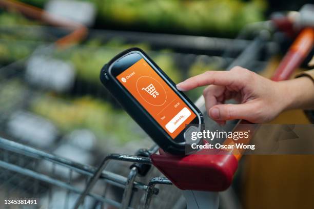 grocery shopping with a smart handset - business as usual stock pictures, royalty-free photos & images