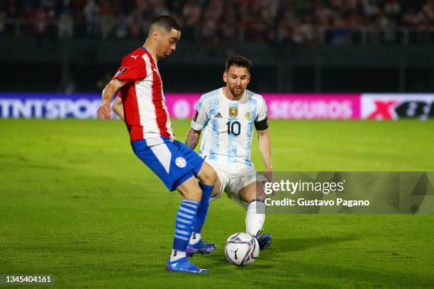 Miguel Almiron of Paraguay and Lionel Messi of Argentina fight for the ball during a match between Paraguay and Argentina as part of South American...