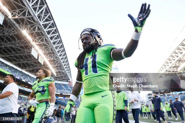 Running back Alex Collins of the Seattle Seahawks waves while walking off the field during warm ups before the start of their game against the Los...
