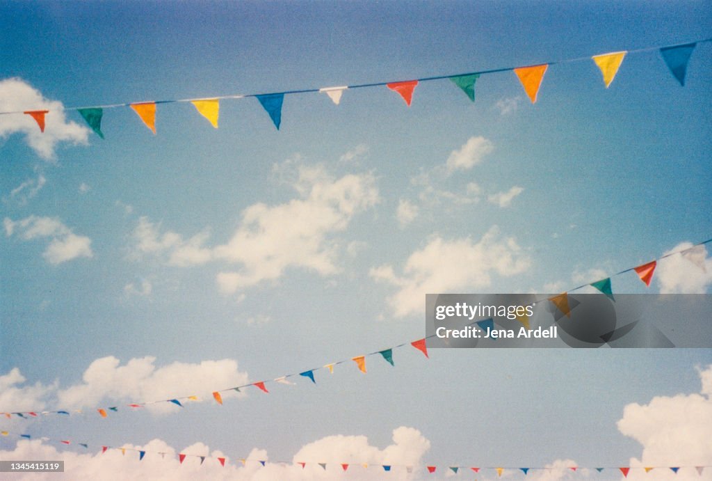 Happiness and celebration: Colorful flags sky background with clouds, rainbow color flags