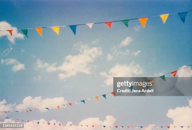 happiness and celebration: colorful flags sky background with clouds, rainbow color flags - fete stock pictures, royalty-free photos & images