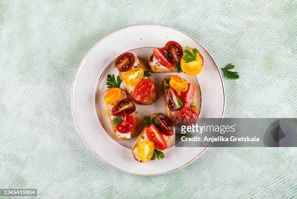 bruschetta with tomato and cream cheese. - cherry tomatoes stock-fotos und bilder