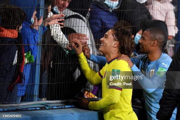 Juan Quintero of Colombia and Nicolas De La Cruz of Uruguay greet fans after a match between Uruguay and Colombia as part of South American...