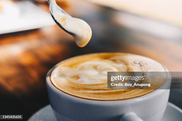 close up of creamy surface of hot latte coffee. - enjoying coffee cafe morning light stock-fotos und bilder