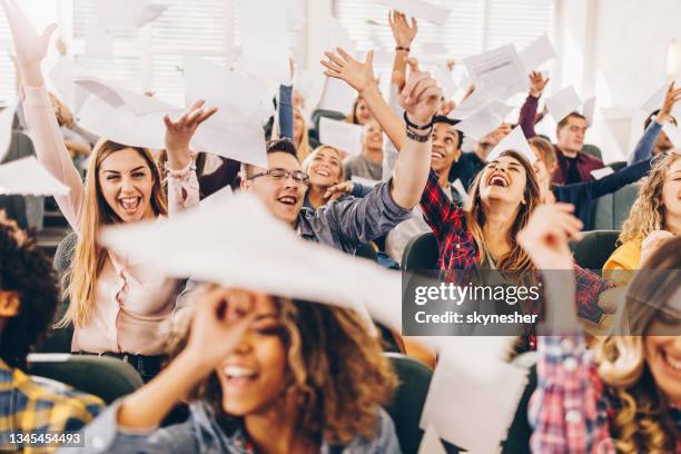 cheerful college students celebrating the end of school year in lecture hall. - fun student stockfoto's en -beelden