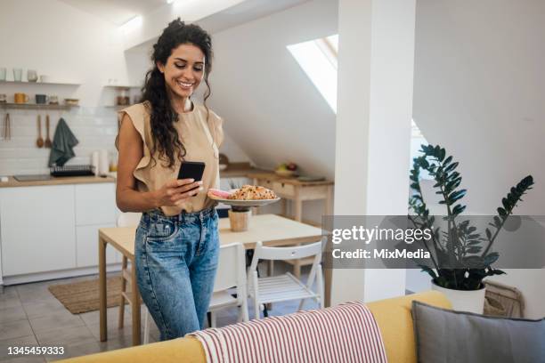 young woman carrying a plate with sweet pastry for snack - carbs bildbanksfoton och bilder