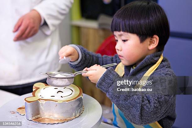 boy making cake - colander foto e immagini stock