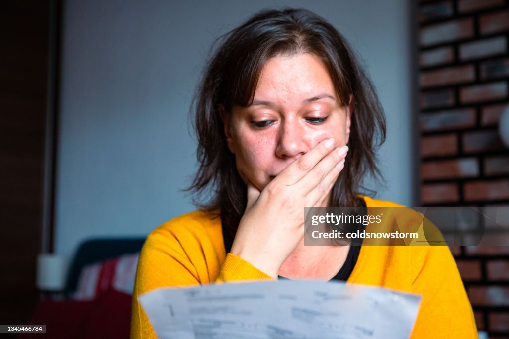 Besorgte Frau, die Rechnungen zu Hause überprüft