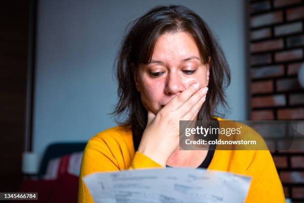 donna preoccupata che controlla le bollette a casa - shocked woman foto e immagini stock