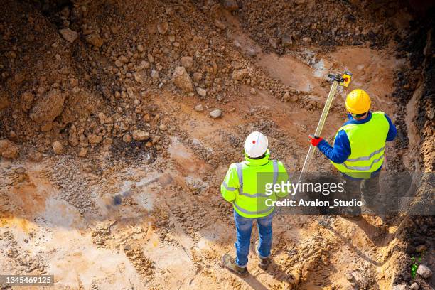 surveyors at the construction site - engineering earth stock pictures, royalty-free photos & images