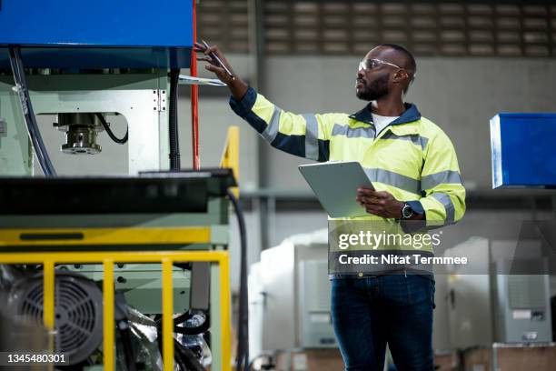 capability studies, helpful machinery to improve a production process. african engineer working in a production line and examining automated machinery workload to making forecasting and planning resource allocation. - business continuity plan bildbanksfoton och bilder