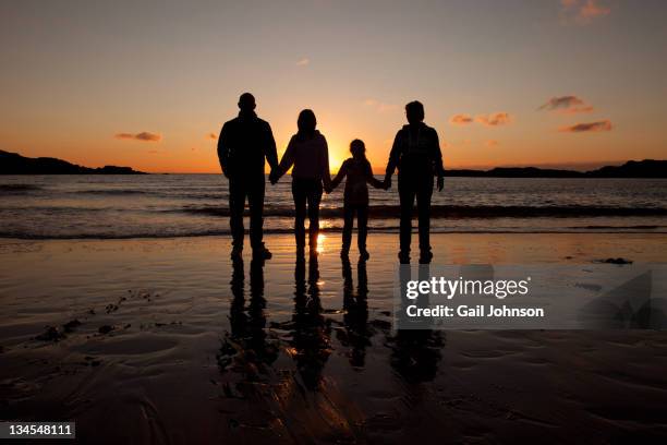 familiy on beach - family of four silhouette fotografías e imágenes de stock