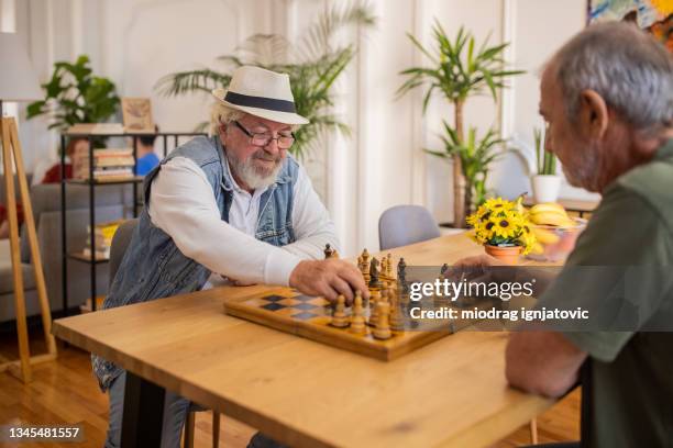 two senior men enjoying chess game at nursing home - assisted living community stock pictures, royalty-free photos & images