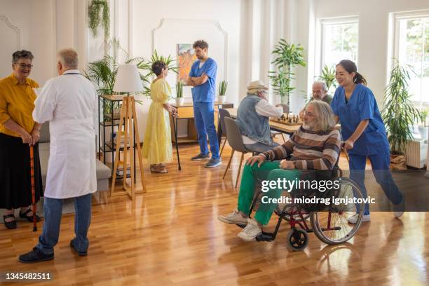 día habitual en residencia de ancianos abarrotada - residencia de ancianos fotografías e imágenes de stock